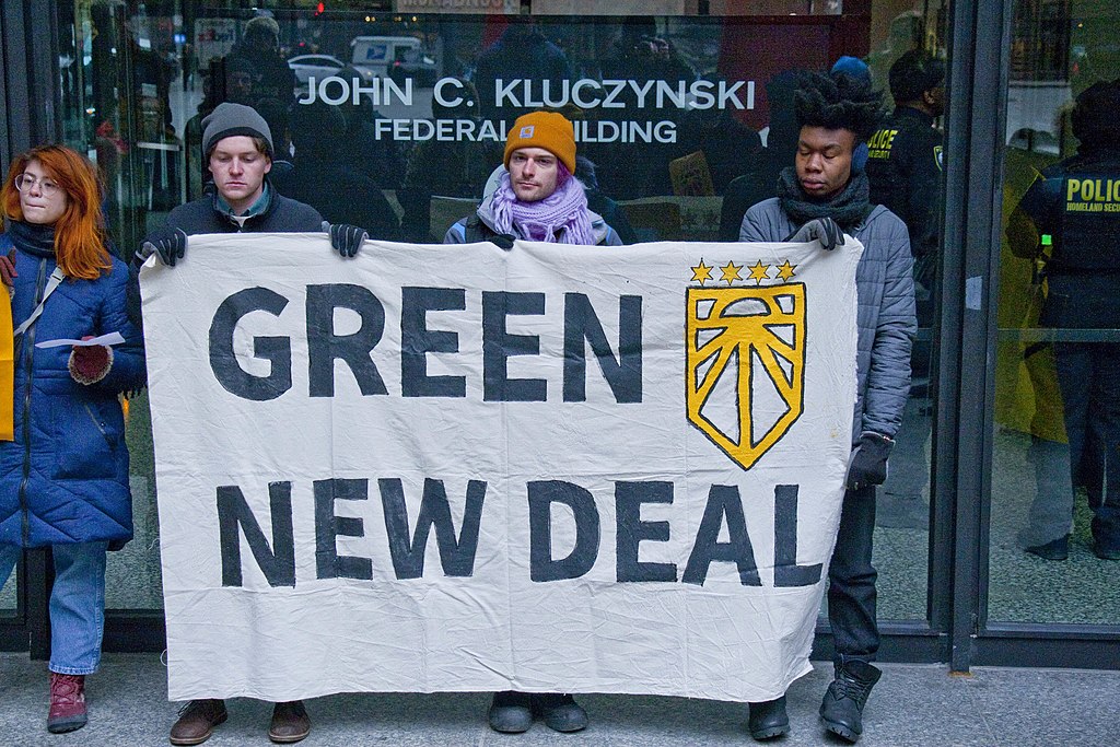 protesters hold green new deal sign